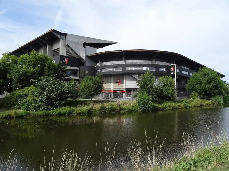 Façade du Roazhon Park au bord de la Vilaine à Rennes, avec l'écusson du Stade rennais sur ses murs