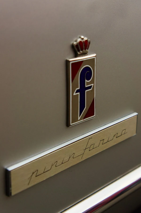 Badge Pininfarina &agrave; couronne et &laquo;&nbsp;f&nbsp;&raquo; bleu au-dessus du lettrage cursif pinin farina sur une carrosserie