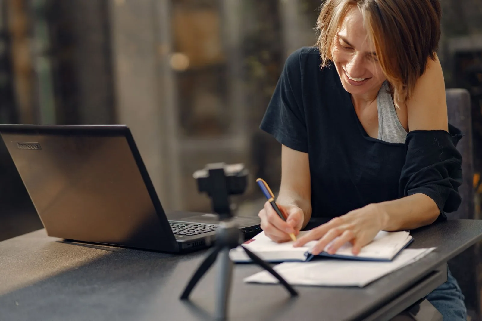 Propriétaire prenant des notes à côté de son ordinateur portable